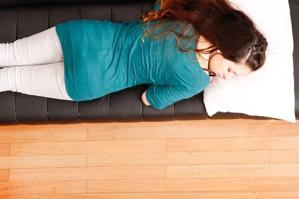 Junge Frau entspannt sich auf Sofa — Stockfoto